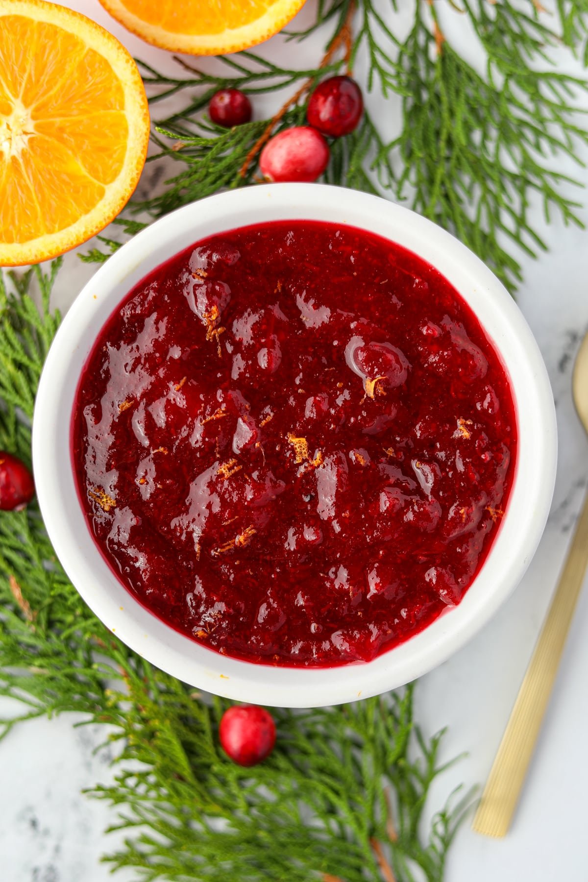 A small bowl of cranberry sauce, garnished with orange zest.