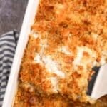 A spatula lifting a portion of casserole from a baking dish.