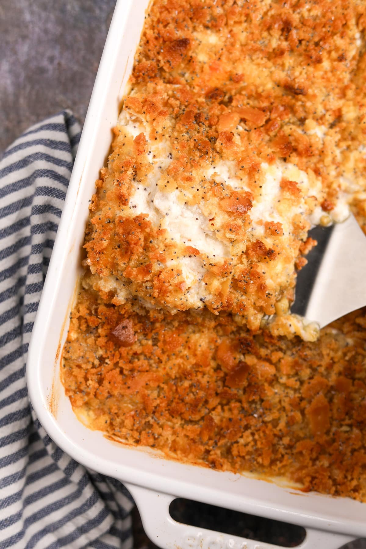 A spatula removing a portion of casserole from a baking dish.