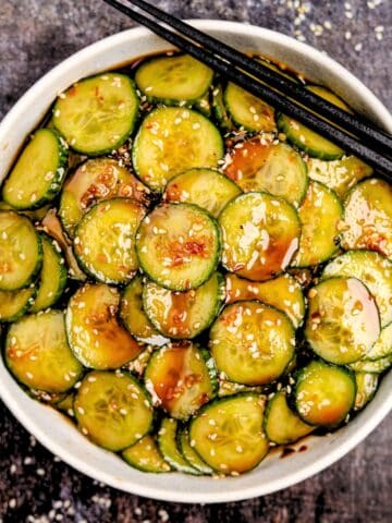 A bowl of cucumber salad glazed with a spicy dressing.