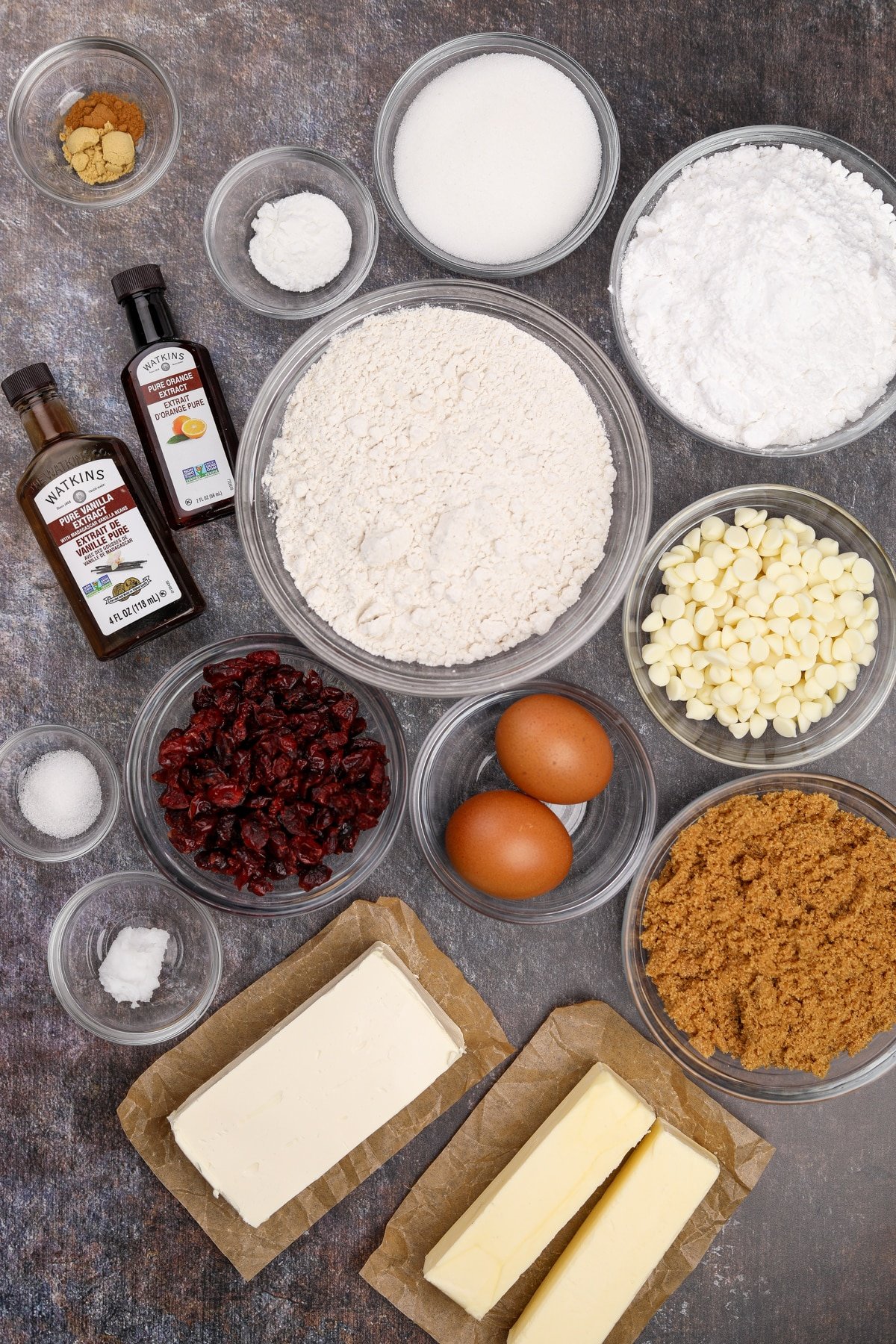 The ingredients needed to make homemade cranberry bliss bars, including flour, butter, cream cheese, eggs, and sugar.