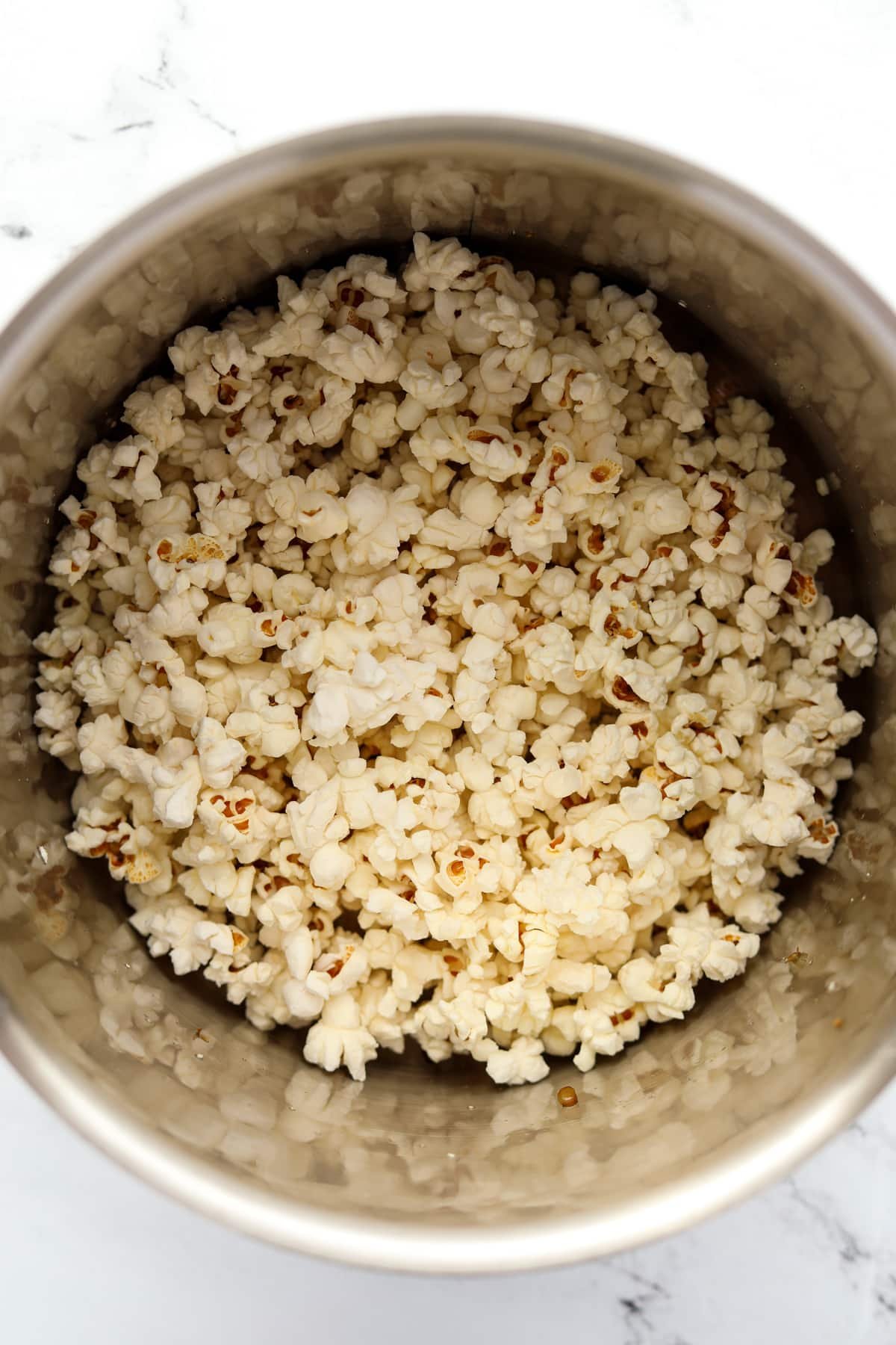 A large pot filled with popped popcorn.
