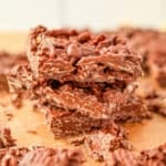 A stack of three pieces of chocolate bark, featuring wavy potato chips.