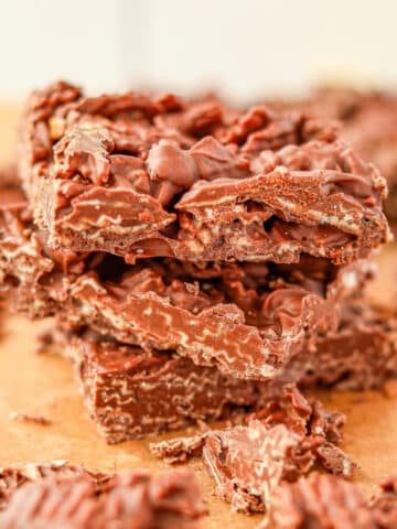 A stack of three pieces of chocolate bark, featuring wavy potato chips.