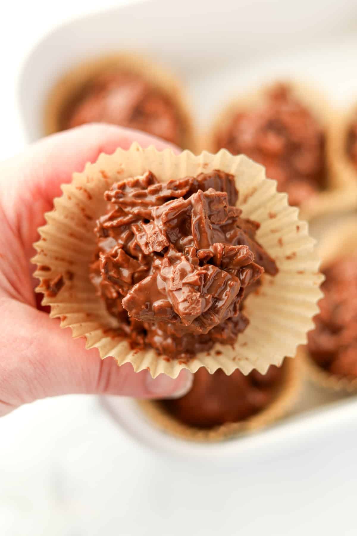 A close up of a chocolate cluster enveloped in a muffin liner.