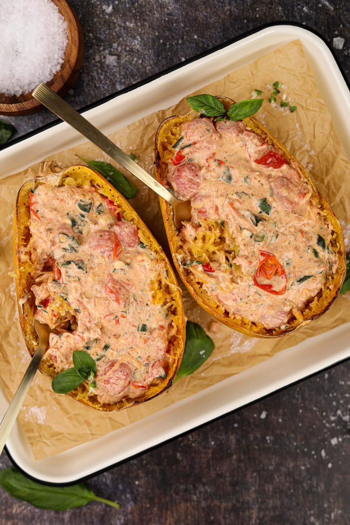 Two Boursin stuffed spaghetti squash halves with forks inside of them.