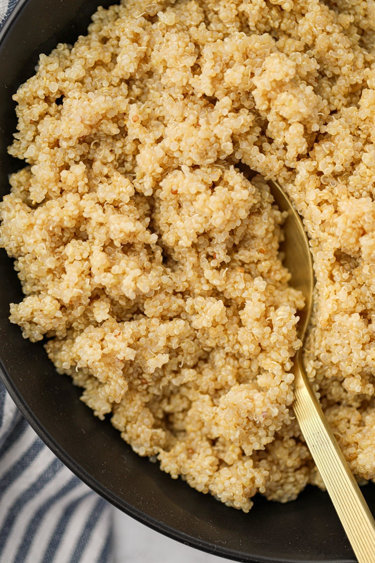 Scooping quinoa from a black bowl.