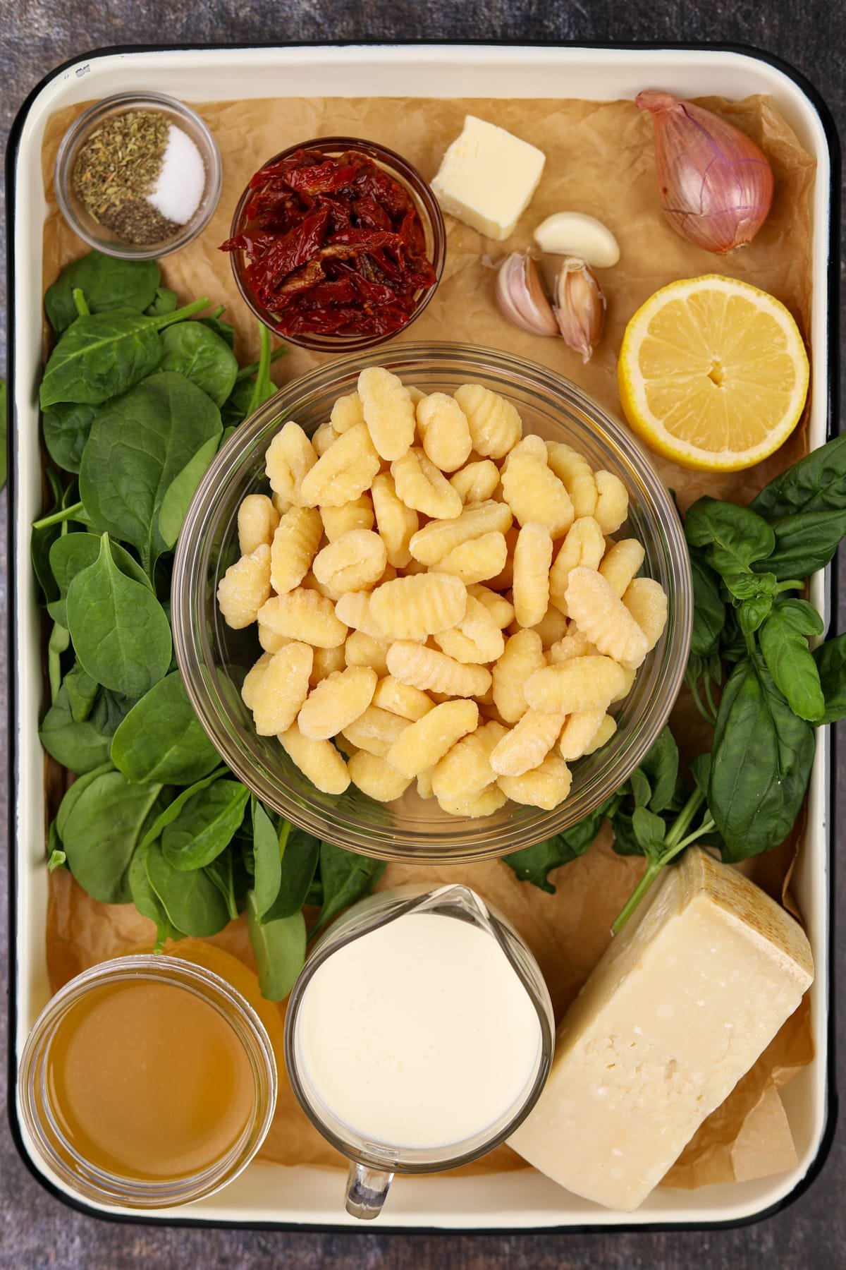 The ingredients needed to make tuscan gnocchi - broth, cream, parmesan, sundried tomatoes, etc.