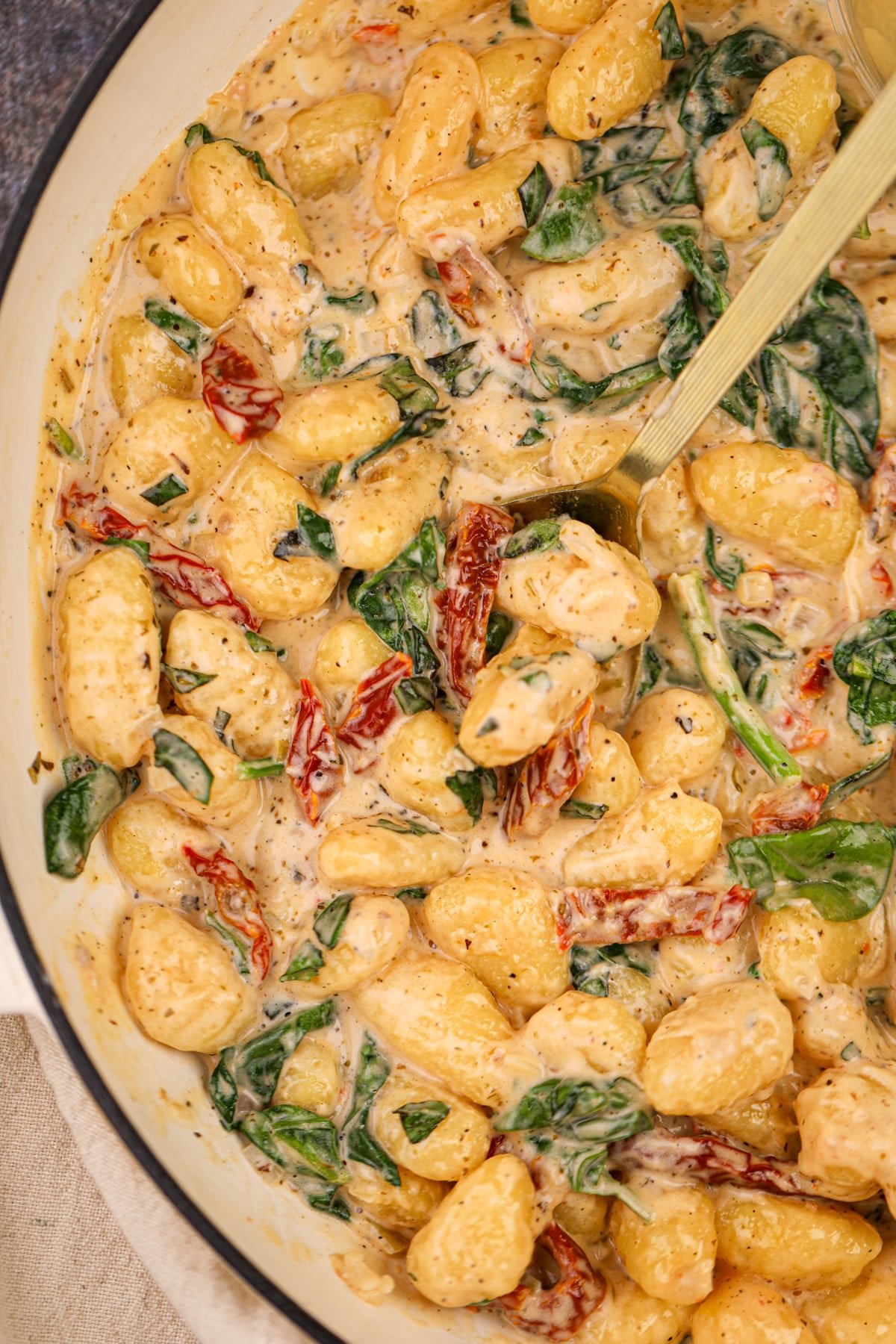 A large skilled filled wtih creamy gnocchi, with a spoon sticking out.