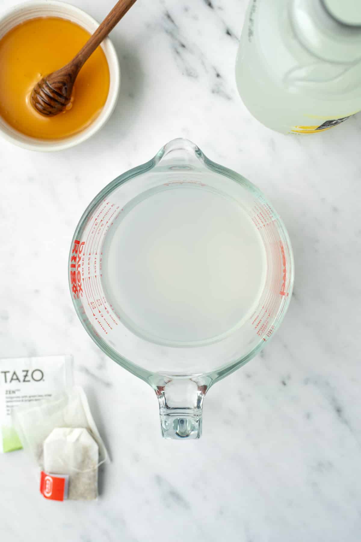 A measuring cup filled with a mix of lemonade and water.
