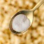 A golden spoon filled with fine salt.