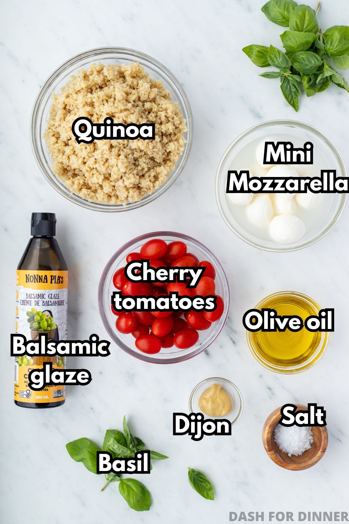 The ingredients needed to make caprese quinoa salad, including cherry tomatoes, basil, and olive oil.