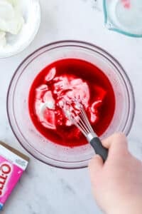 Whisking yogurt into liquid jello.