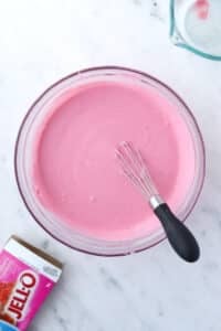 A bowl of greek yogurt mixed with raspberry jello.