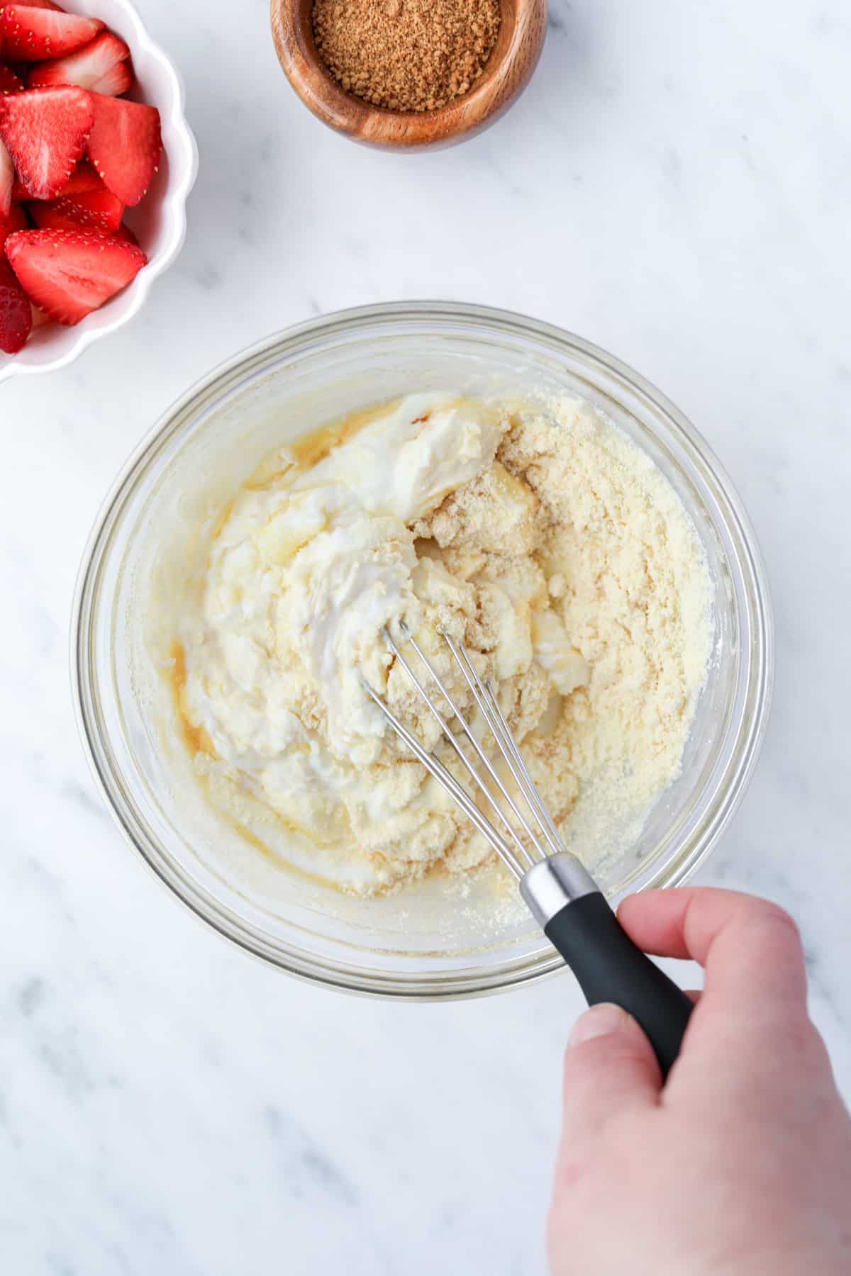 Whisking together a bowl of yogurt with other ingredients.