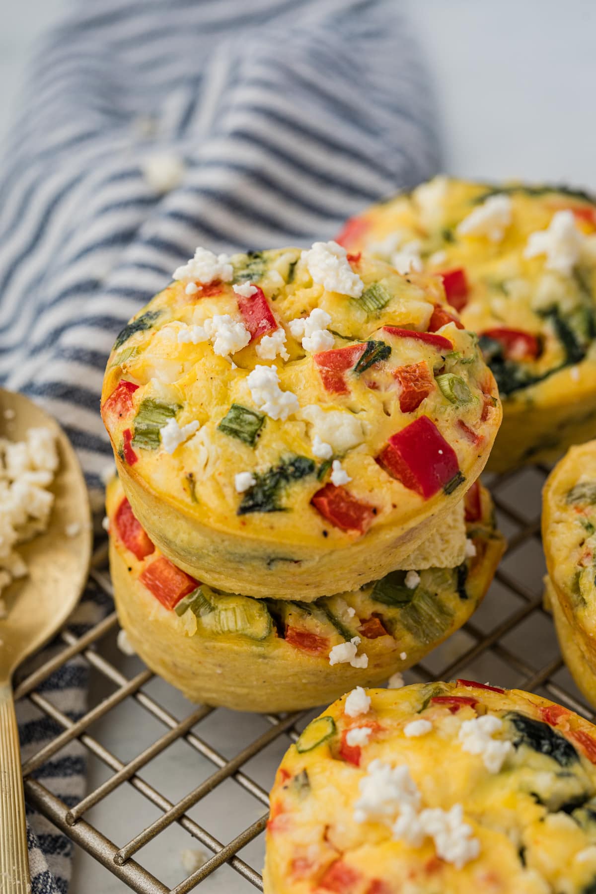 Two egg muffins stacked on top of each other on top of a wire cooling rack.