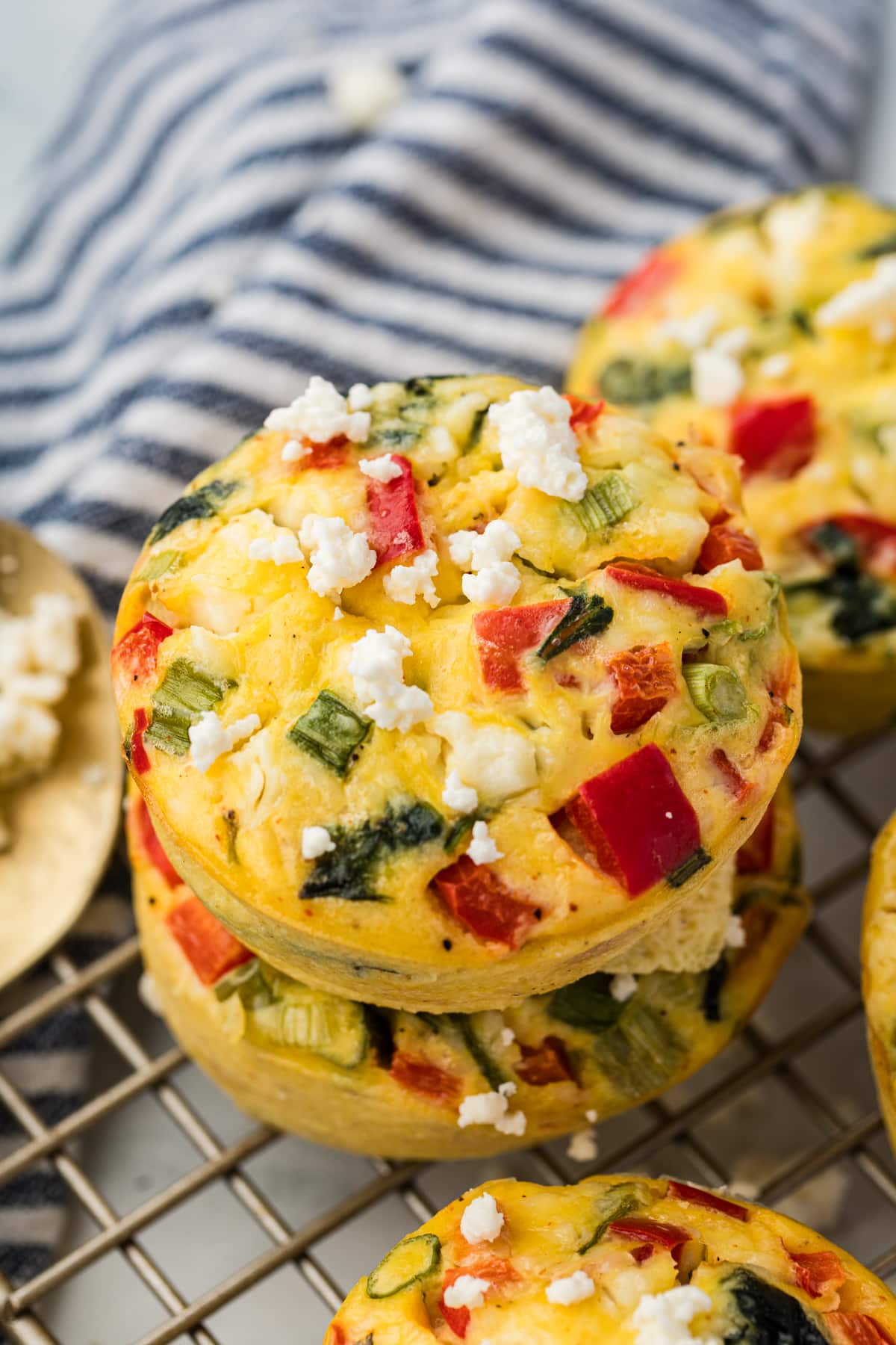 Two spinach egg bites stacked on a wire rack.