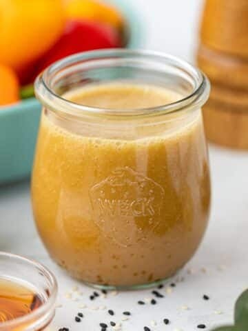 A small jar filled with homemade ginger sesame dressing.