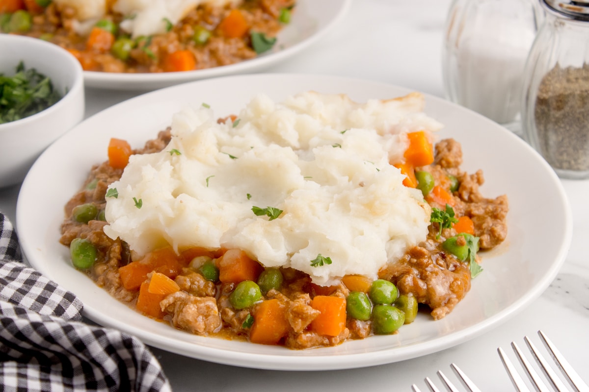 A plate of shepherd's pie topped with fluffy mashed potatoes.