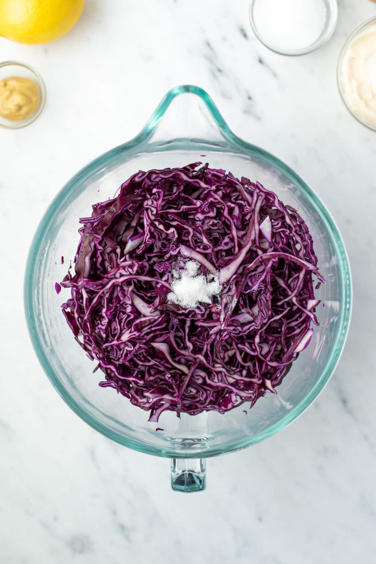 A large glass bowl filled with shredded red cabbage.