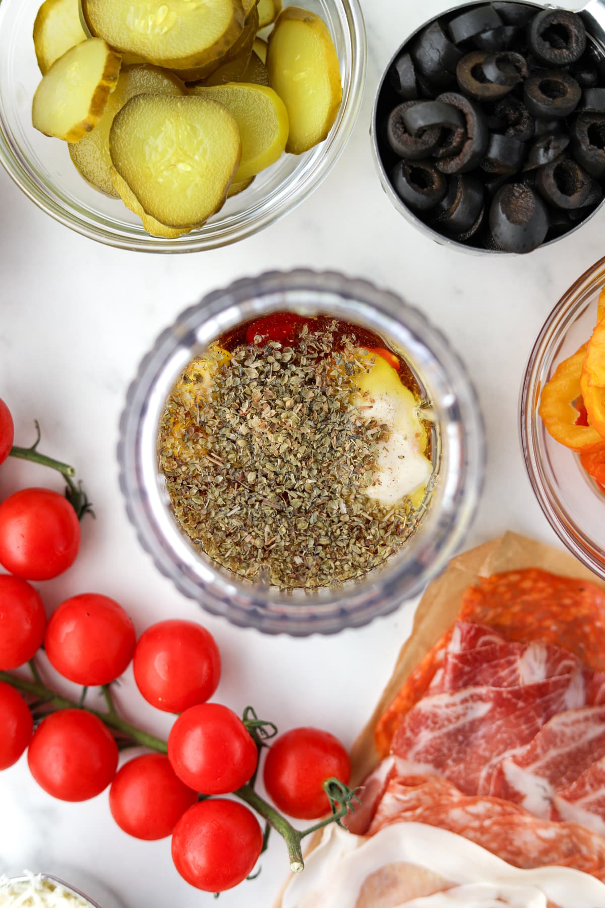 A small jar blender filled with olive oil, oregano, red wine vinegar, etc.