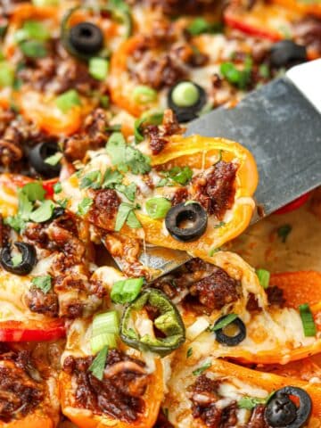 Lifting mini pepper nachos from a sheet pan.