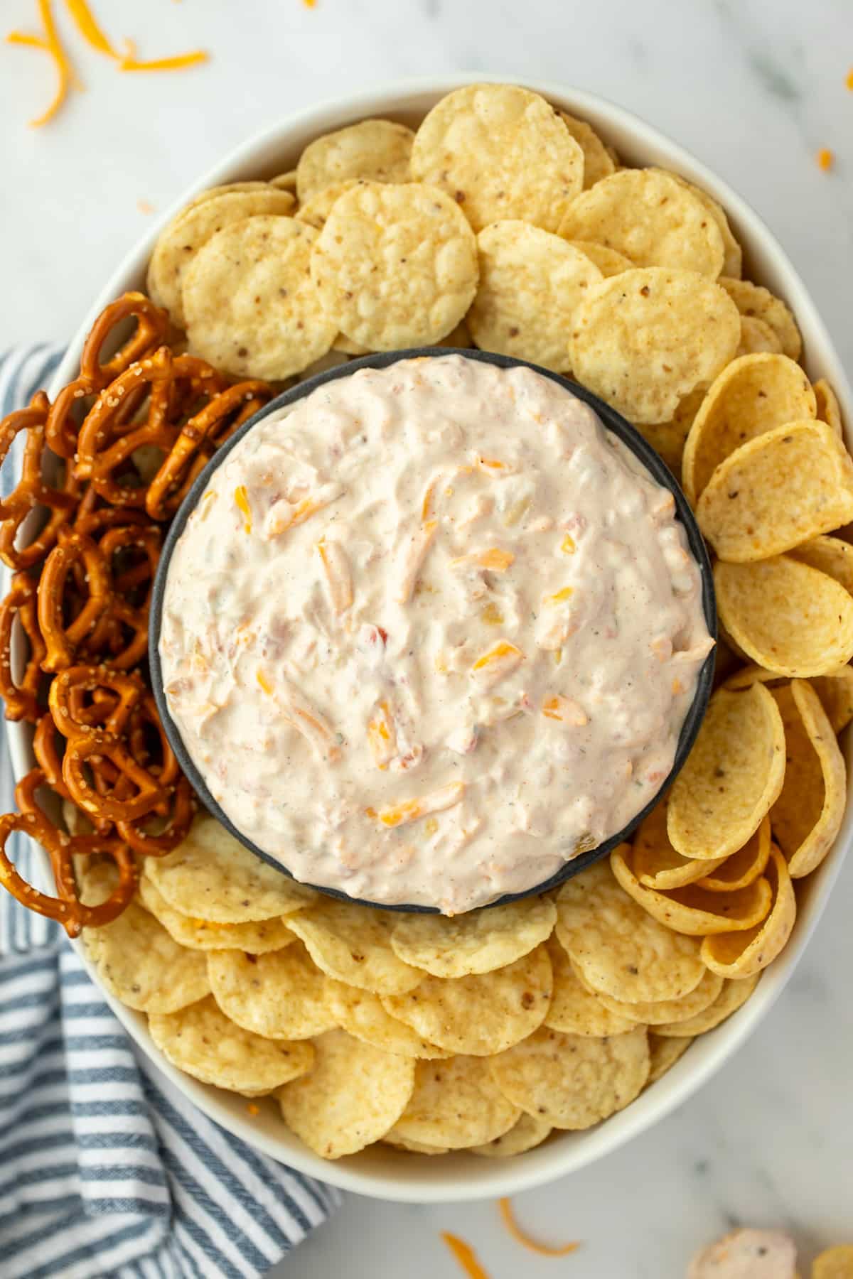 An oval dish filled with tortilla chips, with a bowl of creamy dip in the center.