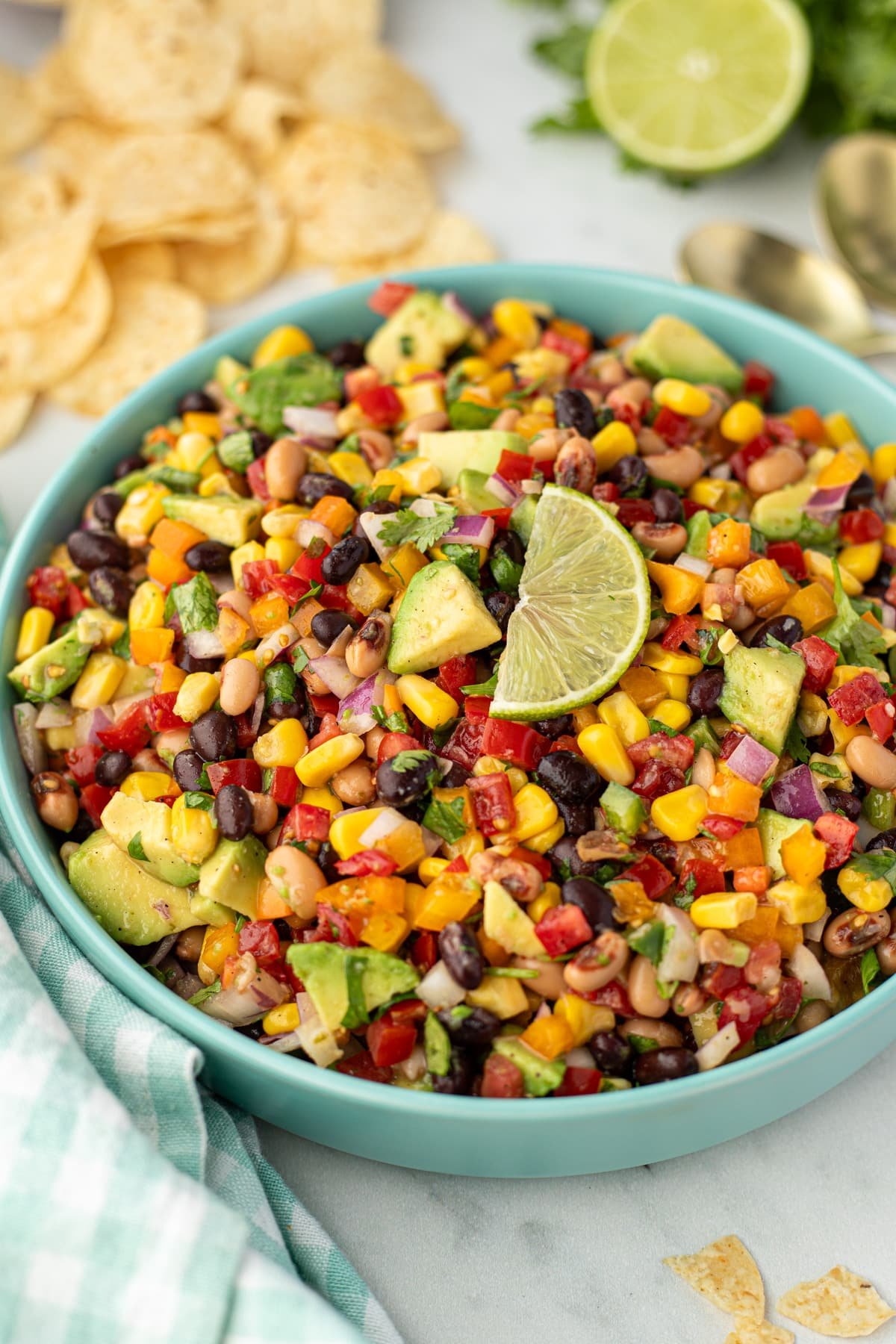 A bowl of bean salad topped with a wedge of fresh lime.