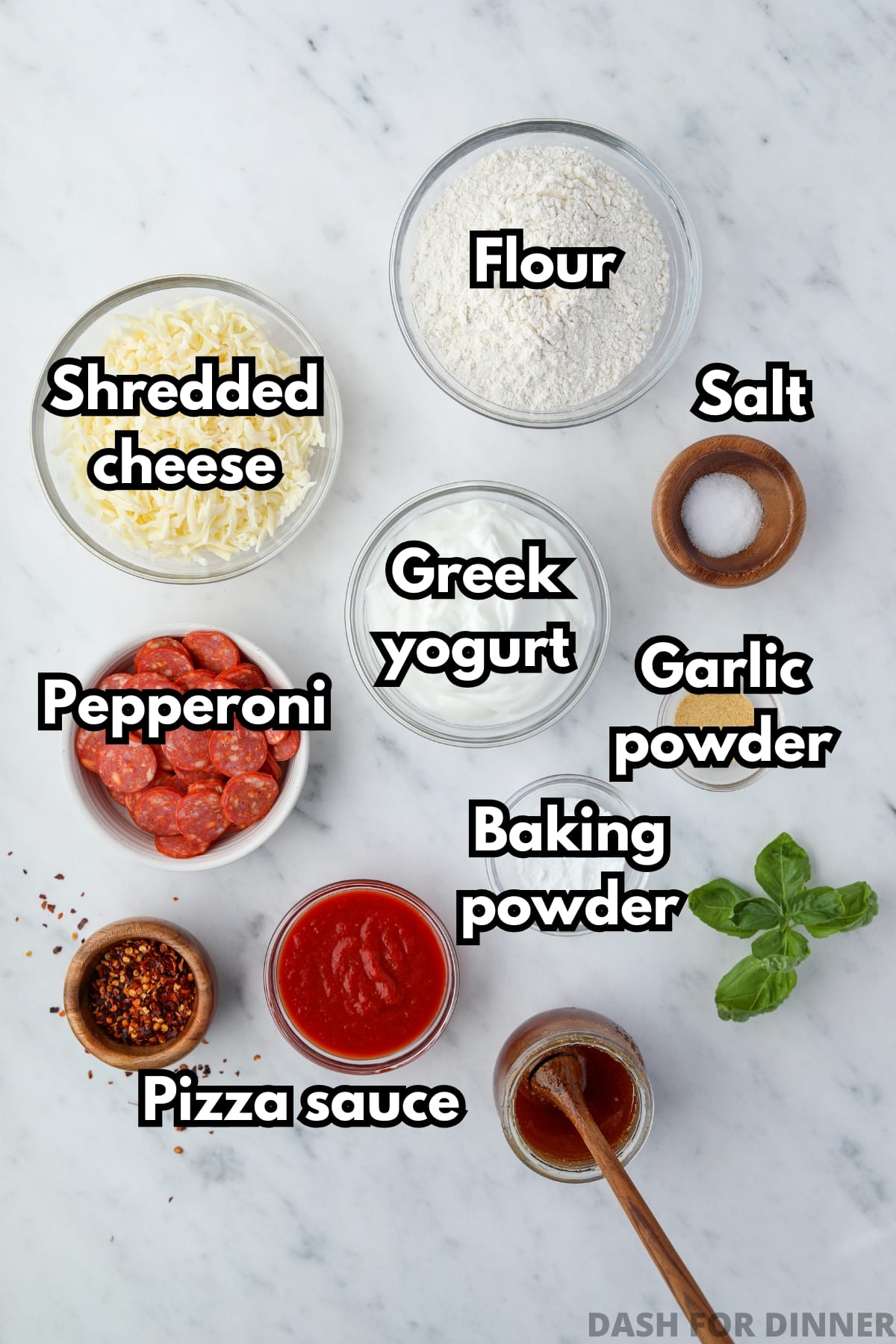 Bowls of the ingredients needed to make greek yogurt pizza, including greek yogurt, flour, and shredded cheese. 
