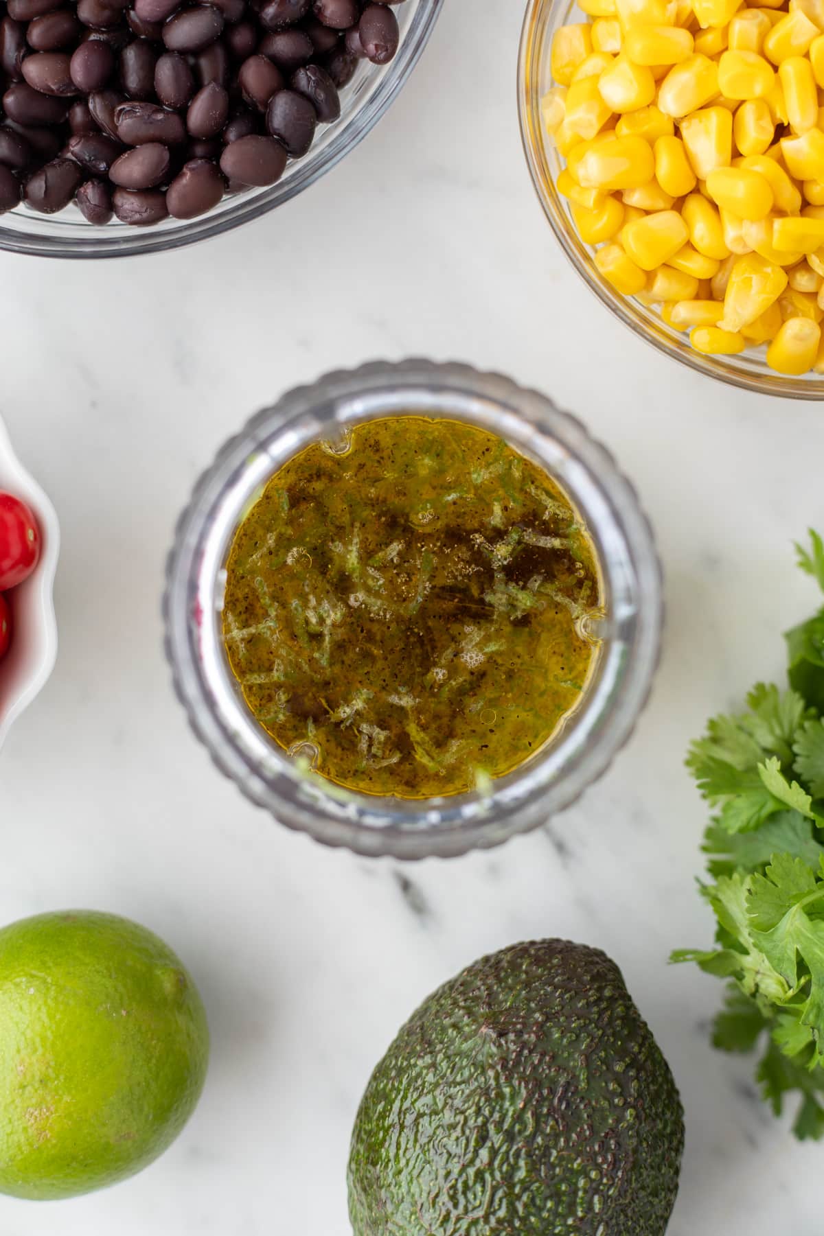 A mini blender filled with olive oil and other various ingredients.