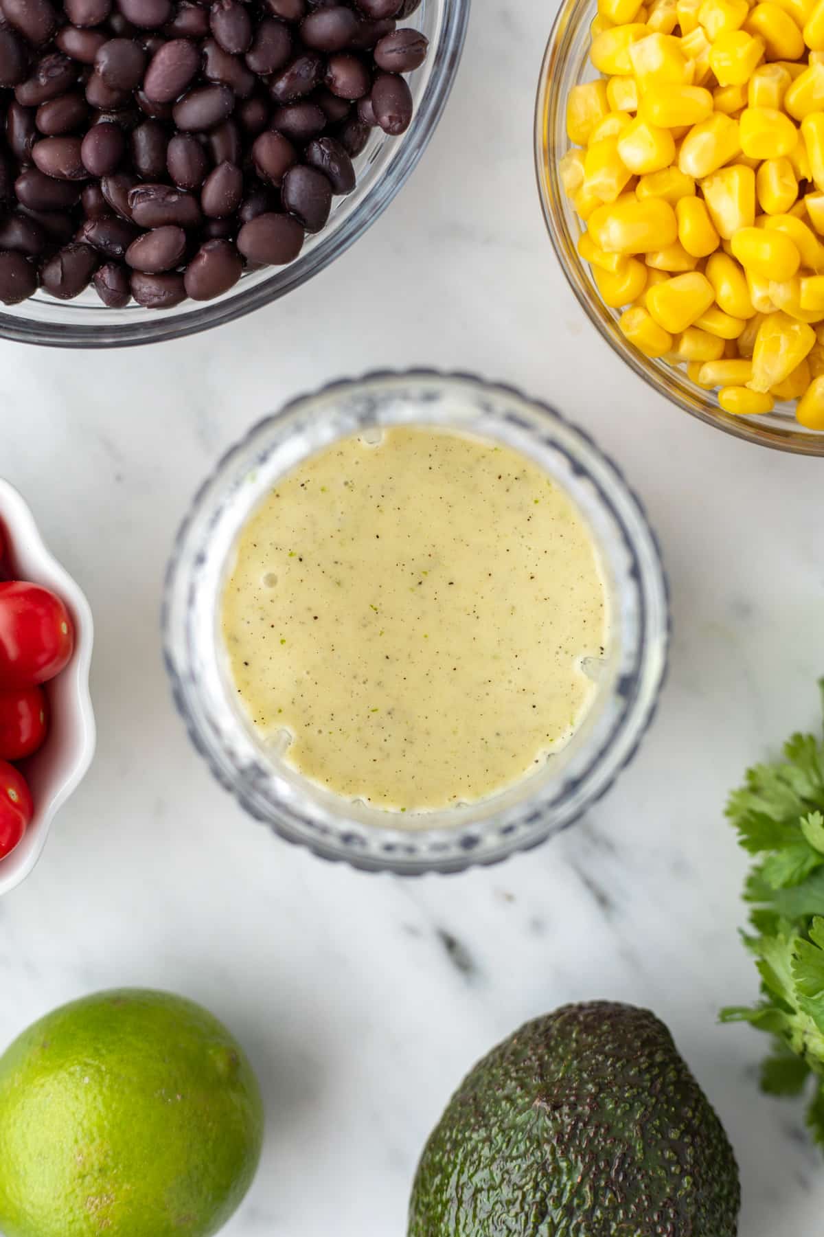 A small blender cup filled with a very light green dressing.