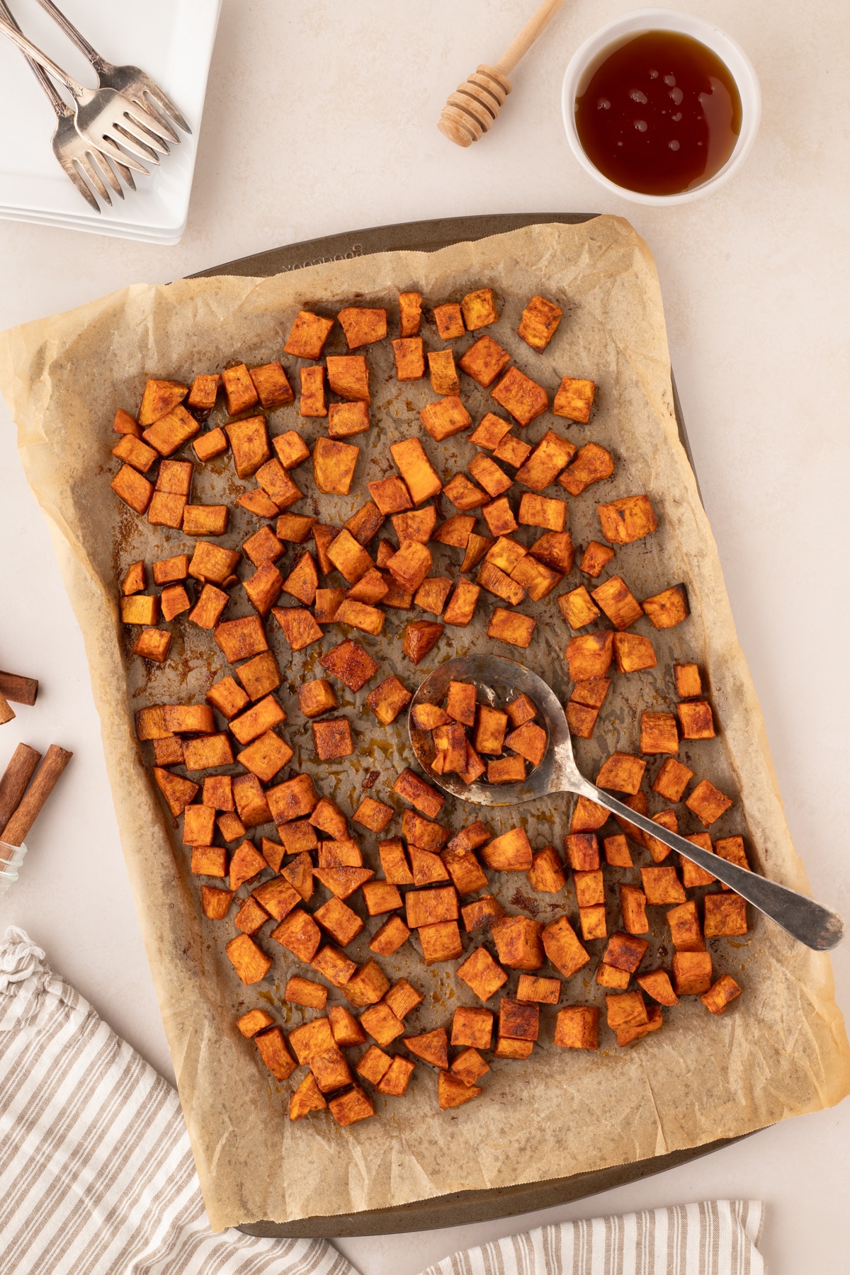 A baking sheet filled with roasted sweet potato cubes.