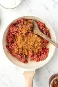 A skillet with ground beef and taco seasoning.