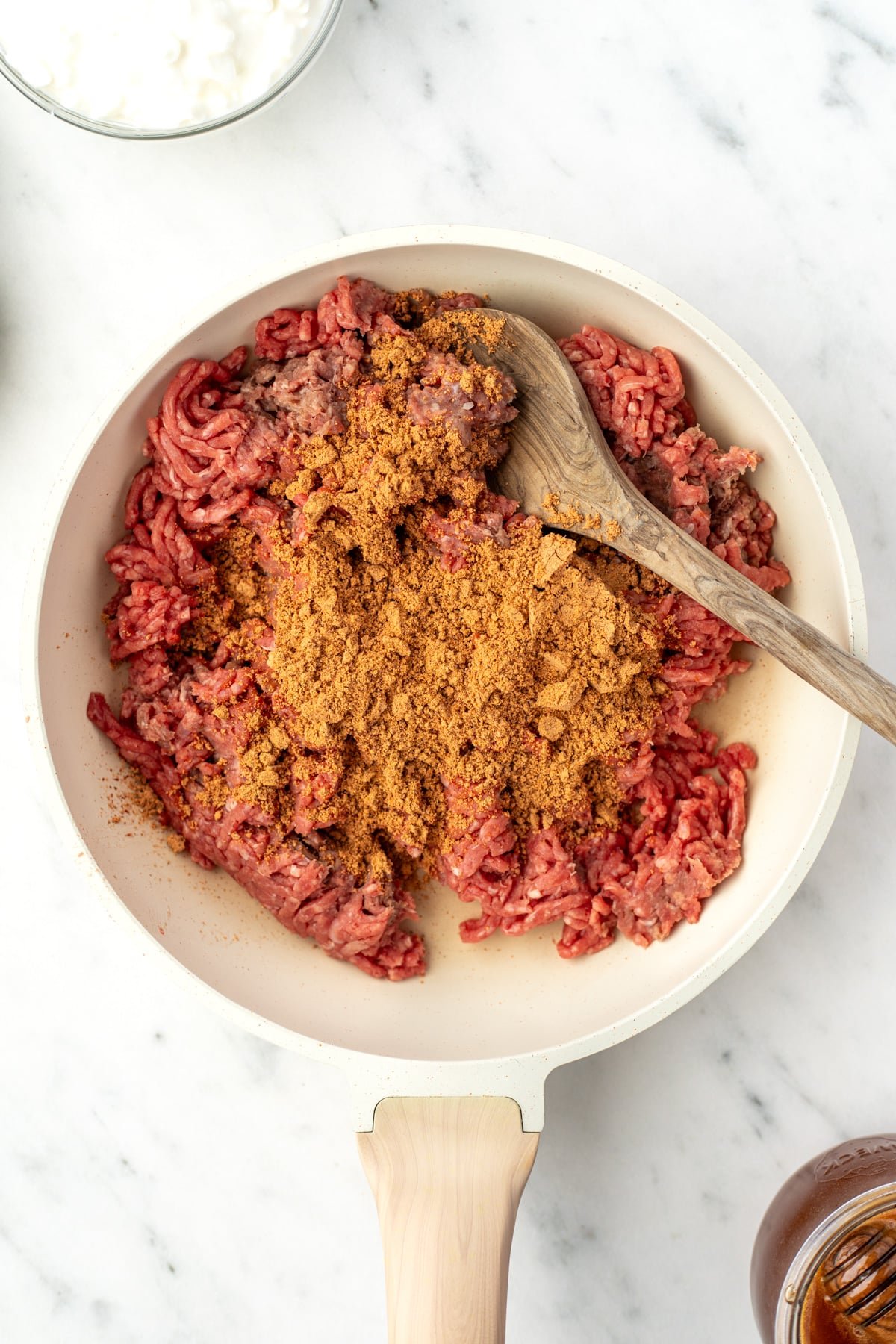 A skillet with ground beef and taco seasoning.