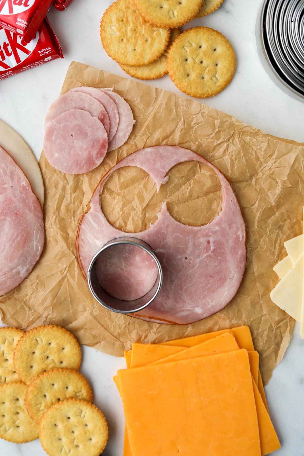 Using a circular cutter to slice deli meat into rounds.