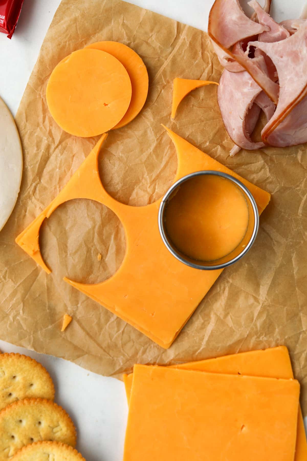 Using a circular cutter to slice cheese into rounds.