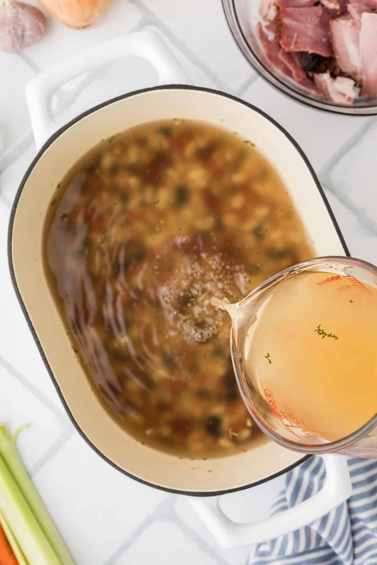 Pouring broth into a large pot.