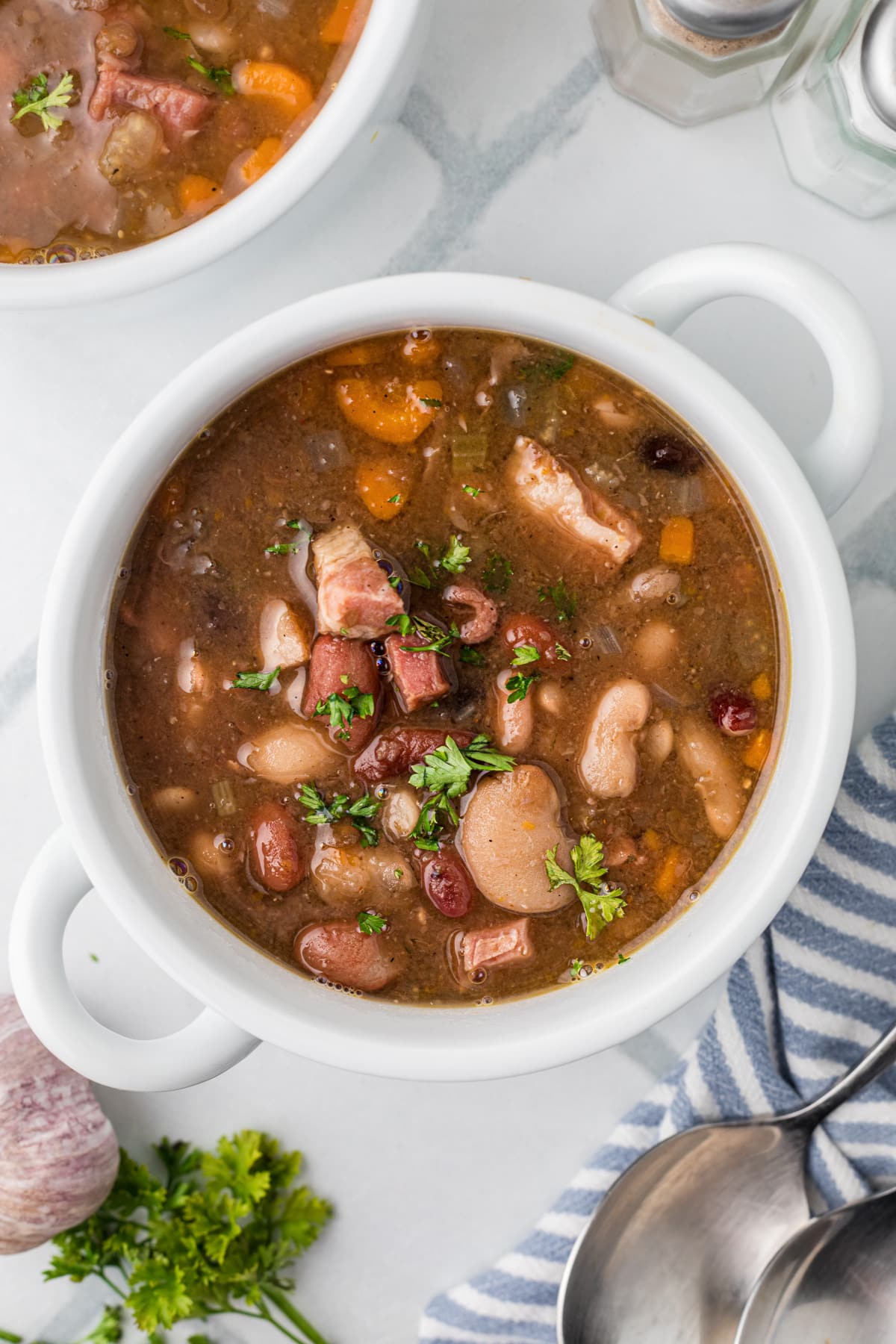 A bowl of bean soup filled with bits of ham.