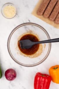 A bowl of oil and seasonings mixed together.