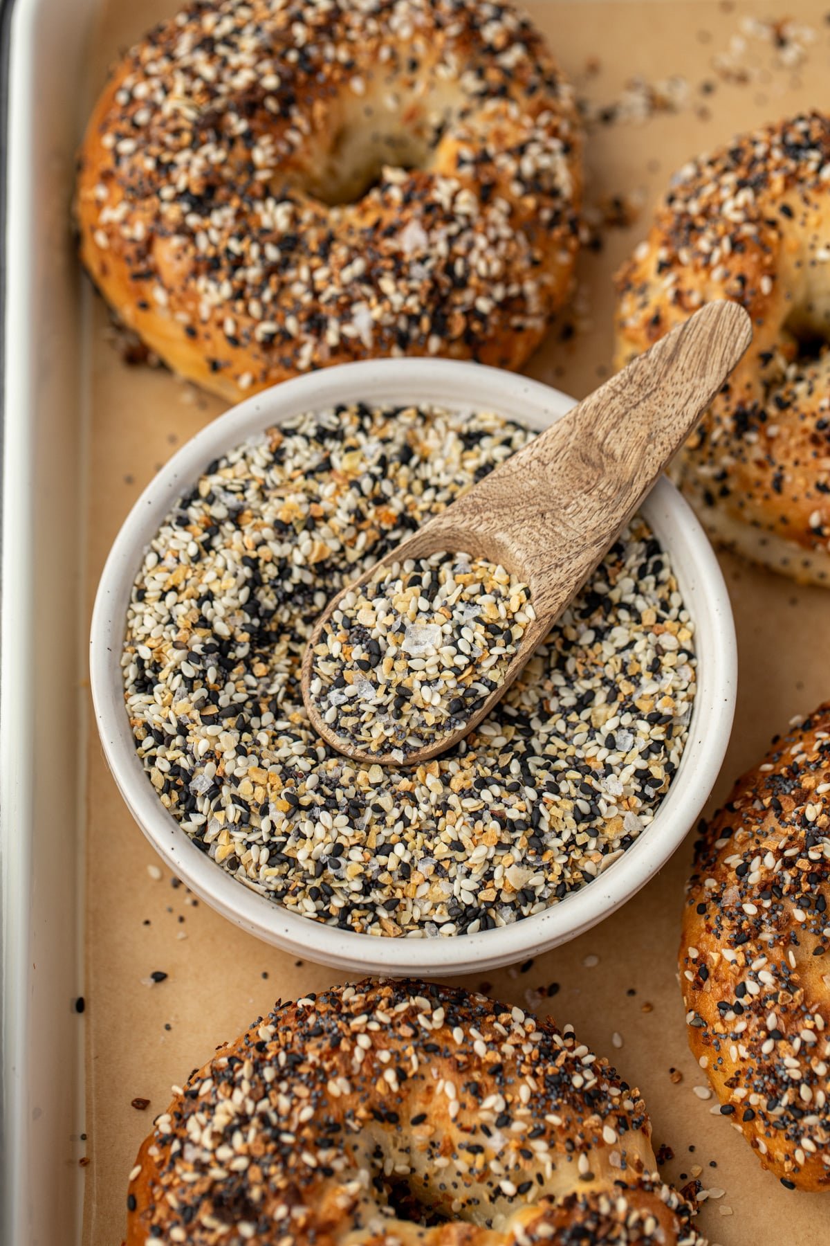 A small bowl of everything but the bagel seasoning with a small wooden spoon.