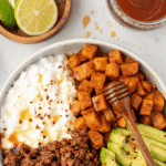 A bowl featuring sections of ground beef, sweet potato, cottage cheese, and optional avocado.