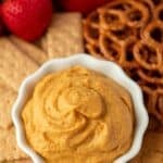 A bowl of pumpkin pie dip surrounded by graham crackers, pretzels, and gingersnaps.