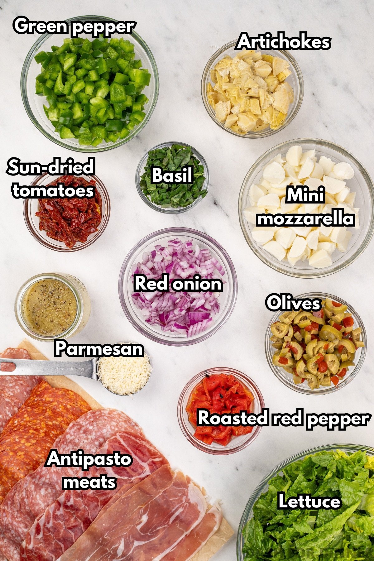Bowls of ingredients for a salad, including red onion, green pepper, mozzarella, etc.