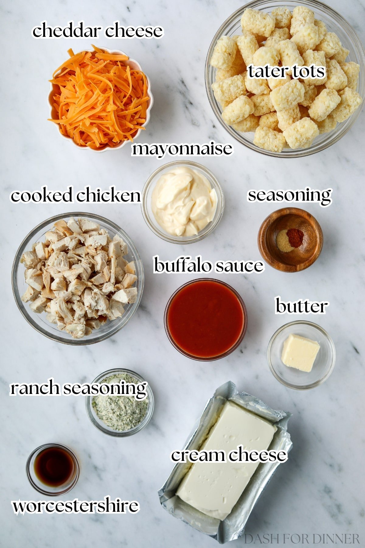 The ingredients needed to make buffalo chicken casserole, including cooked chicken, cheese, and cream cheese.