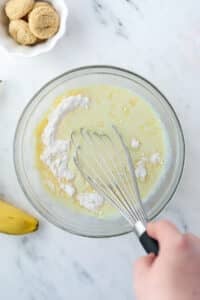 Whisking pudding mix into liquid.