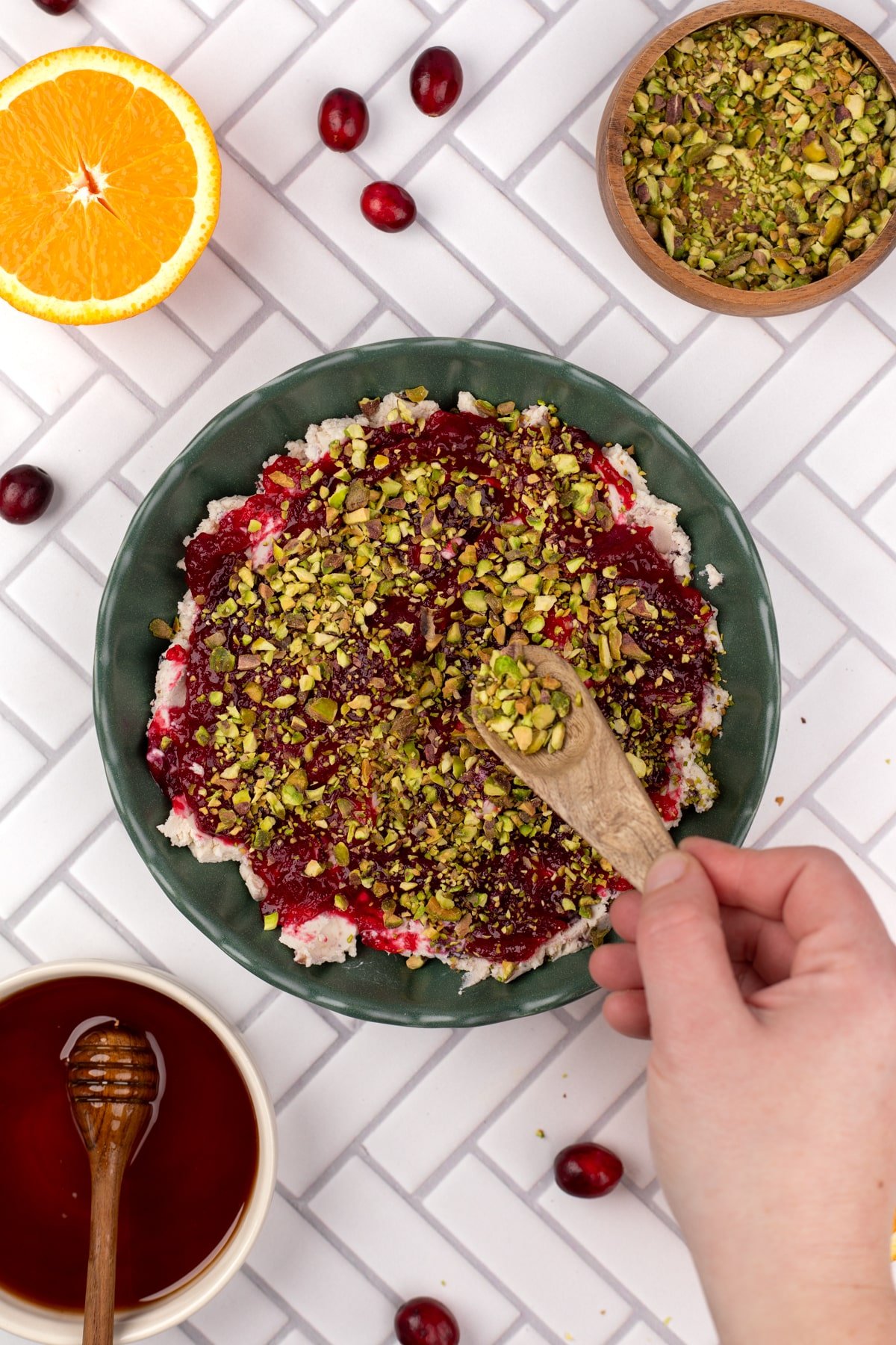Sprinkling pistachios on top of the cranberry layer.