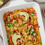 A baking dish filled with fajita casserole, topped with avocado, jalapeno, and cilantro.