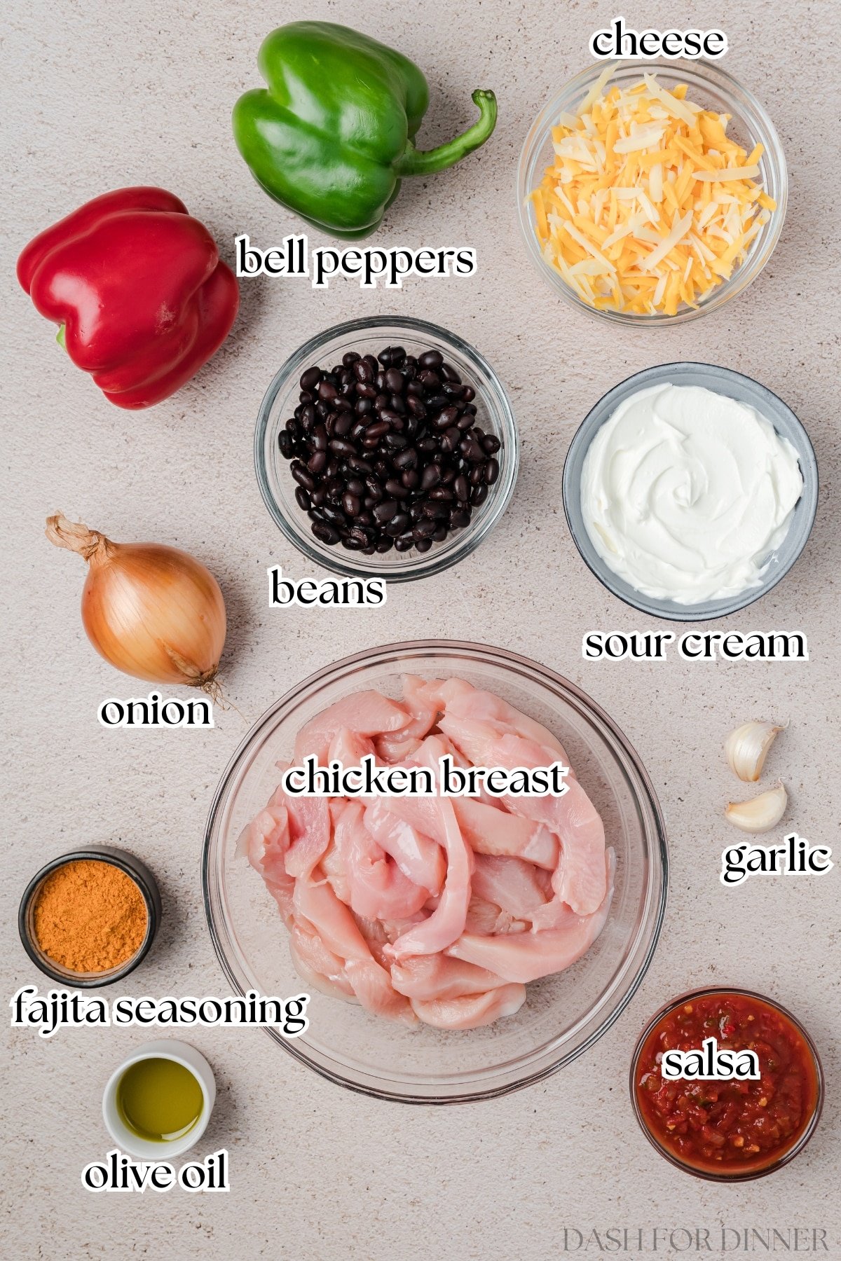 The ingredients needed to make fajita casserole, including chicken, cheese, beans, sour cream, and seasoning.