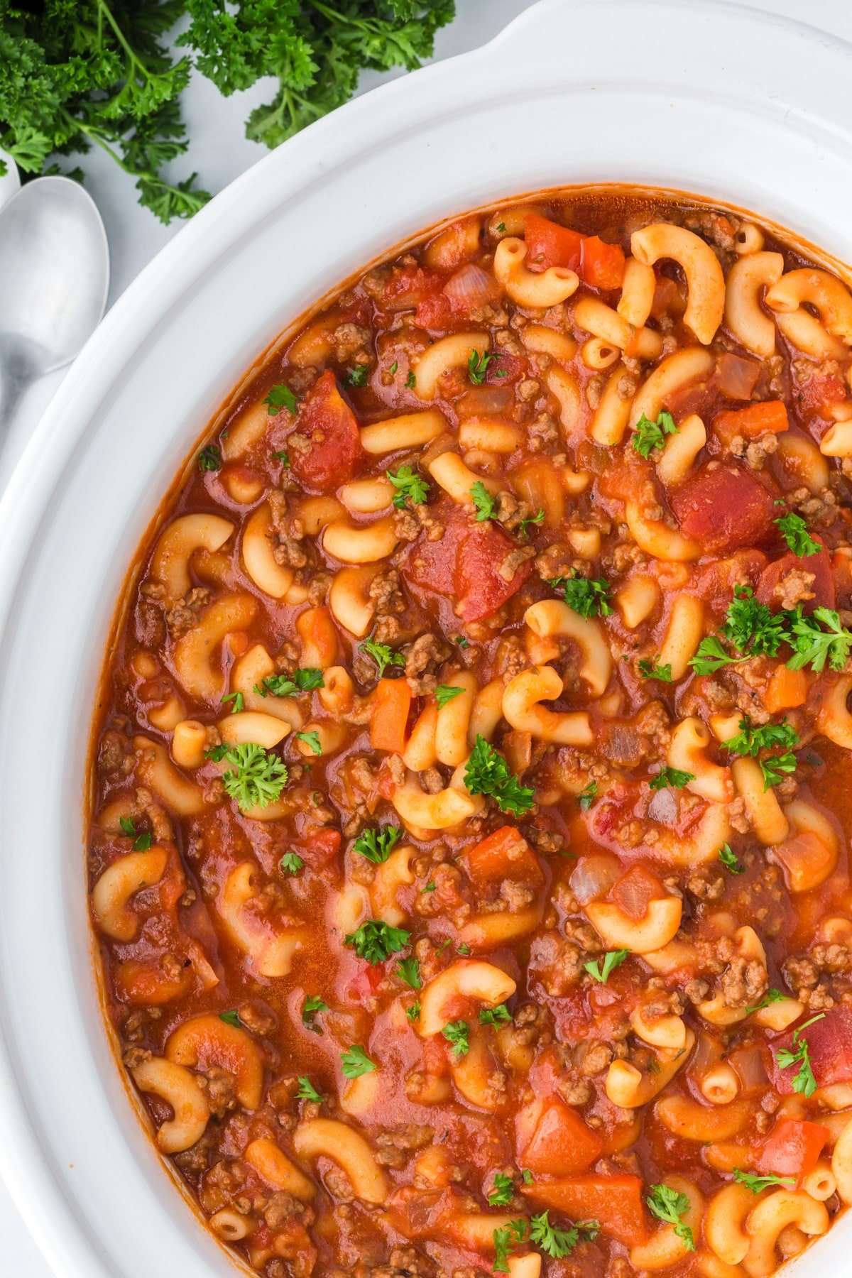 A slow cooker filled with ground beef and macaroni.