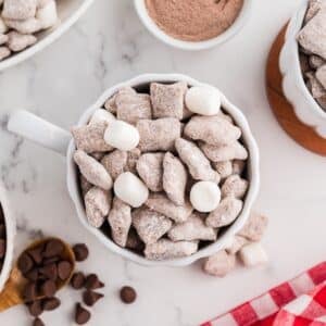 A mug of muddy buddies, dotted with random mini marshmallows.